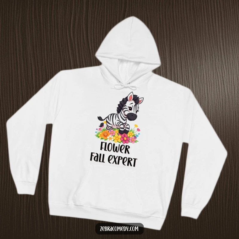Funny zebra comically slipping on a patch of colorful flowers, a comfortable and amusing hoodie for lighthearted moments.