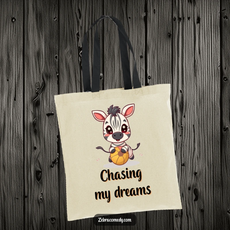 Funny zebra character with eyes wide in playful pursuit of a bouncy ball, featured on a durable tote bag.
